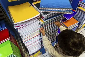 Child Education Drucke: A child is reaching for a notebook on a shelf