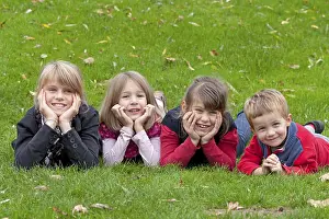 Happy Children Outdoors Drucke: Four children lying on a meadow