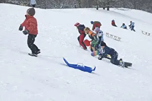 Snow Covered Mountain Landscape Drucke: Three children are pulling their sledge up the hill