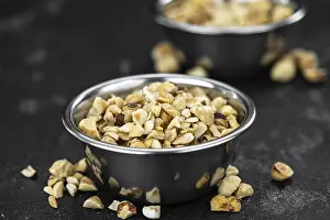 Close Up Hazelnuts Drucke: Chopped Hazelnuts on rustic background as close up shot (selective focus)