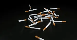 Addictive Drug Health Risks Drucke: Cigarettes Falling against Black Background