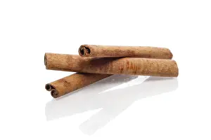 Studio Shot Dessert Drucke: Three cinnamon sticks with reflection on white background
