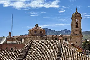 Drucke von Stadtlandschaft mit einem alten Uhrenturm, umgeben von vielen Dächern und Bergen im Hintergrund, Die Kirchen der Stadt Potosi in Bolivien Bolivien Kulturerbestätten Drucke: Stadtansicht mit altem Uhrenturm.
