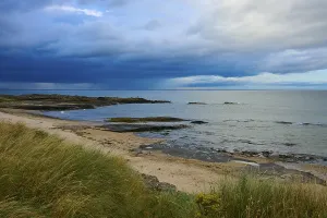 Atmospheric Coastal Scene Drucke: Cliffs and sandy beach on coast under dramatic sky