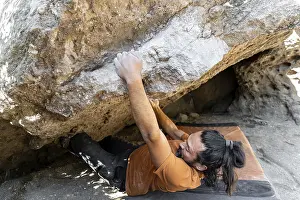 Fitness Training Exercise Drucke: A climber skillfully maneuvers over a challenging boulder in a pristine natural setting