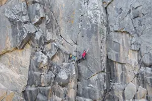 Traditional Rock Climbing Drucke: Climbers scale a rugged cliff using traditional techniques