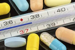 Medical Care Concept Drucke: A clinical thermometer and tablets