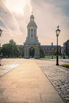European Symbolic Image Drucke: Clock tower with paved path and lanterns in warm morning light