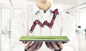 Entrepreneurial Success Story Drucke: Close of businessman holding tablet with progressing graph