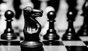 Dark Colored Background Drucke: Close up of Chess pieces on a reflective mirror board surface with a plain black background