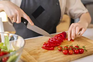 Kitchen Utensil Detail Drucke: Close up hand cutting pepper