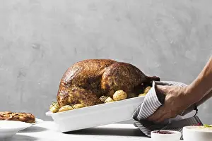Empty Dining Table Setup Drucke: Close up hands putting turkey on table