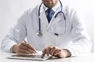 White Medical Uniform Drucke: Close up of male doctor hands using tablet computer