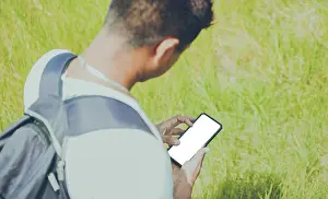 Young Adult On Phone Drucke: Close up of a man with cell phone in hand