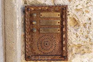 Traditional Building Design Drucke: Close up of an old rusty intercom embedded in weathered stone wall