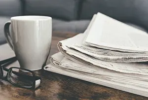 Cozy Living Room Scene Drucke: close-up shot of stack of newspapers