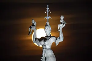 Drucke von Nahaufnahme einer Statue von der Seite, beleuchtet vom Mond, der eine mysteriöse Atmosphäre schafft, Imperia-Statue, Hafen, Konstanz, Baden-Württemberg Imperia Drucke: Nahaufnahme einer Statue von der Seite.