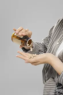 Medical Care And Wellbeing Drucke: Close up view of pill falling out of a jar