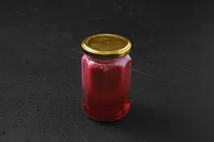 Organic Product Photography Drucke: Whole closed jar of cherry jam on black background