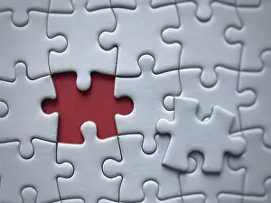 Detailed Close Up Shot Drucke: Closeup of a puzzle with a missing piece against a red background