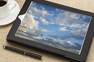 Cloud Computing Concept Drucke: Cloud computing concept - a stormy cloudscape on digital tablet computer together with a cup of coffee and stylus pen