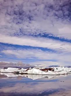 Cloudy Sky Reflections Drucke: Clouds and ice floes are reflected in the smooth water surface