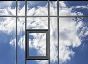 Uninhabited Construction Site Drucke: Clouds are reflected in the house facade