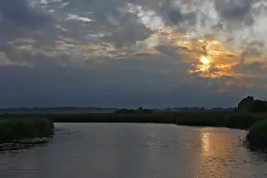 Nature Park Peenetal Drucke: Cloudy sky at sunset over a river with slight reflection