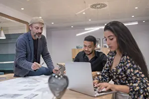 Business Teamwork Drucke: Co-workers using laptop while working together in a new project