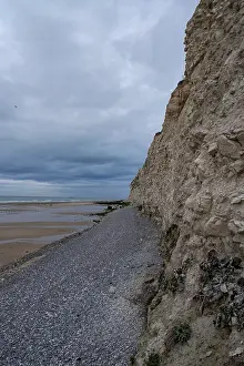 Cloudy Sky Photography Drucke: A coastal cliff is visible under a cloudy sky