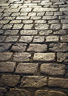 Cobblestone Road Surface Drucke: Cobblestone pavement in the backlight