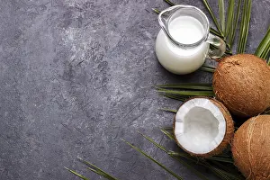 Tropical Fruit Photography Drucke: Coconut shell and milk over black rustic background