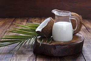 Tropical Fruit Photography Drucke: Coconut shell and milk on brown rustic background
