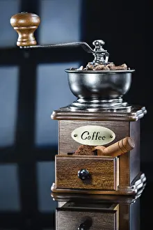 Hipposideridae Drucke: Kaffee-Mühle mit Bohnen auf abstraktem Hintergrund.