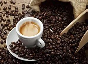 Rustic Wooden Table Decor Drucke: Coffee cup with burlap sack of roasted beans on rustic table