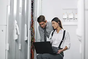 Colleagues Working Together Drucke: Colleagues working on maintaining a server room
