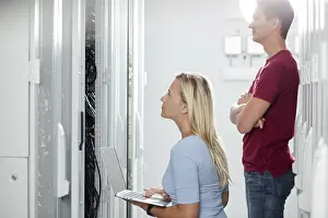 Colleagues Working Together Drucke: Colleagues working on maintaining a server room