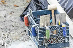 Deserted Construction Area Drucke: Collection of cement and tile installation tools at construction site