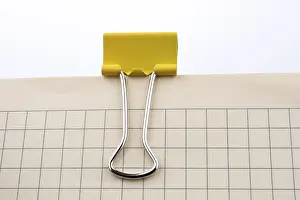 Colorful Stationery Drucke: Colored paper clip on a checked notebook page