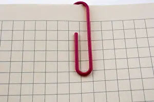 Office Supply Stationery Drucke: Colored paper clip on a checked notebook page