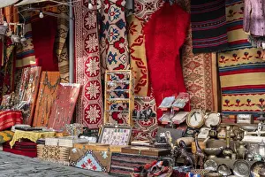 Drucke von Farbvolles Bazaar-Stand mit Teppichen, Schmuck und Handwerkskunst in Gjirokastra, Bezirk Gjirokastër, Albanien Farbvolles Bazaar-Stand mit Teppichen, Schmuck und Handwerkskunst in Gjirokastra Verwandte Bilder Drucke: Farbenfroher Bazarstand mit Teppichen.
