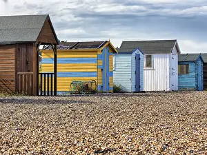 English Channel Coast Drucke: Colourful beach huts on the shingle beach