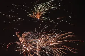 Firework Display Drucke: Colourful rays of light from a firework display glow in the dark sky