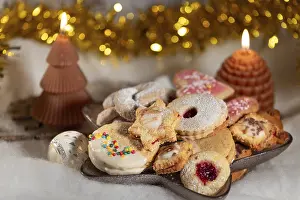 Decorative Food Display Drucke: Colourful selection of biscuits with two burning candles