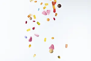 White Background Sweets Drucke: Colourful sweets fall against a white background