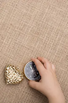 Empty Landscape Drucke: Compass, key and a heart shaped object beside a hand