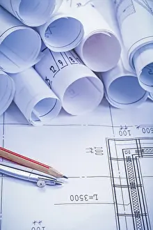 Building Construction Plan Drucke: Compass pencil and big stack of white rolled up blueprints