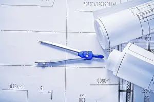 Construction Plan Drucke: Compass and two rolled up white blueprints horizontal version