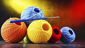Composition with assortment of different colored yarns and hook for crocheting