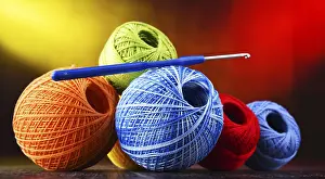 Composition with assortment of different colored yarns and hook for crocheting